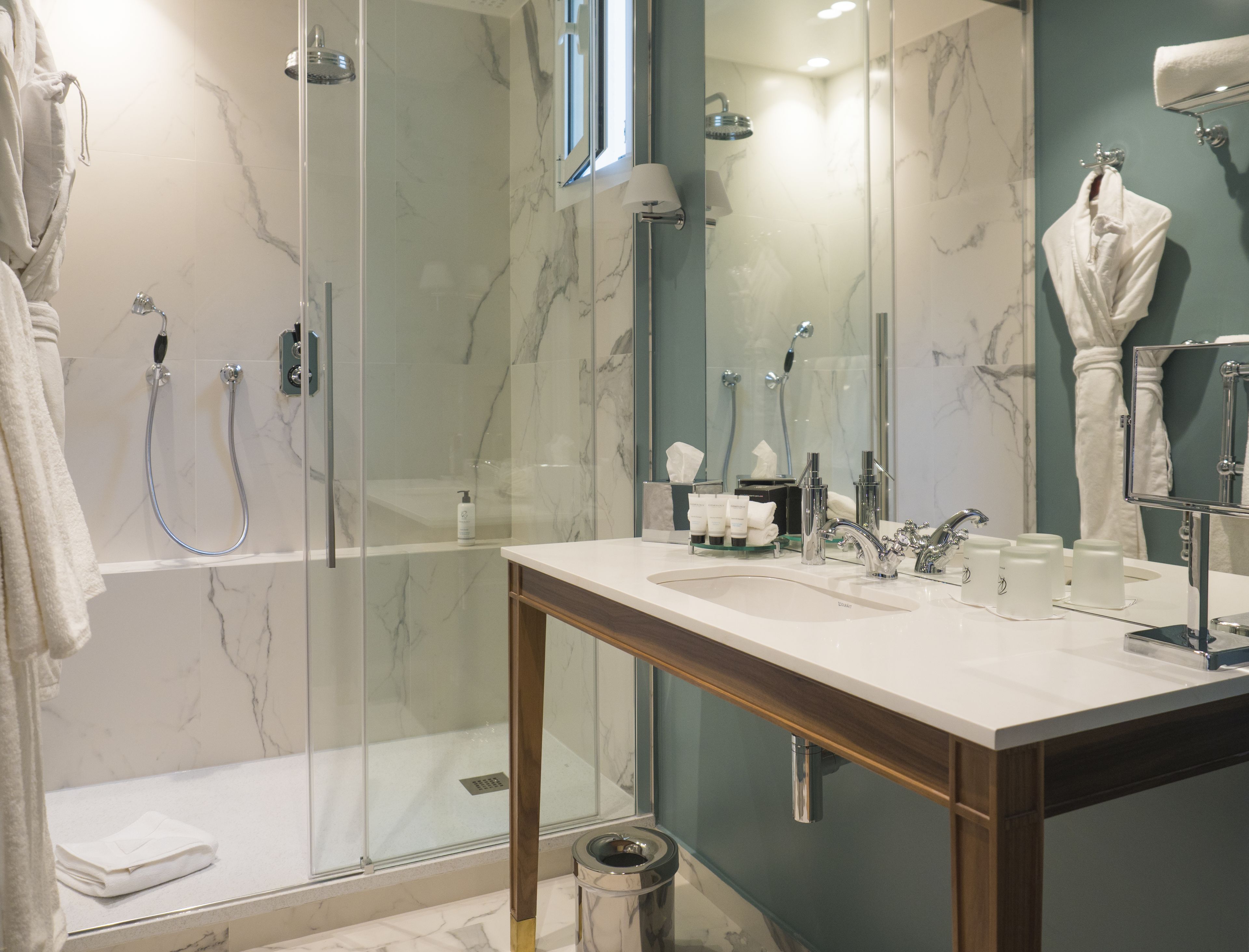 Un bagno moderno con doccia vetrata, un mobile lavabo e uno specchio.