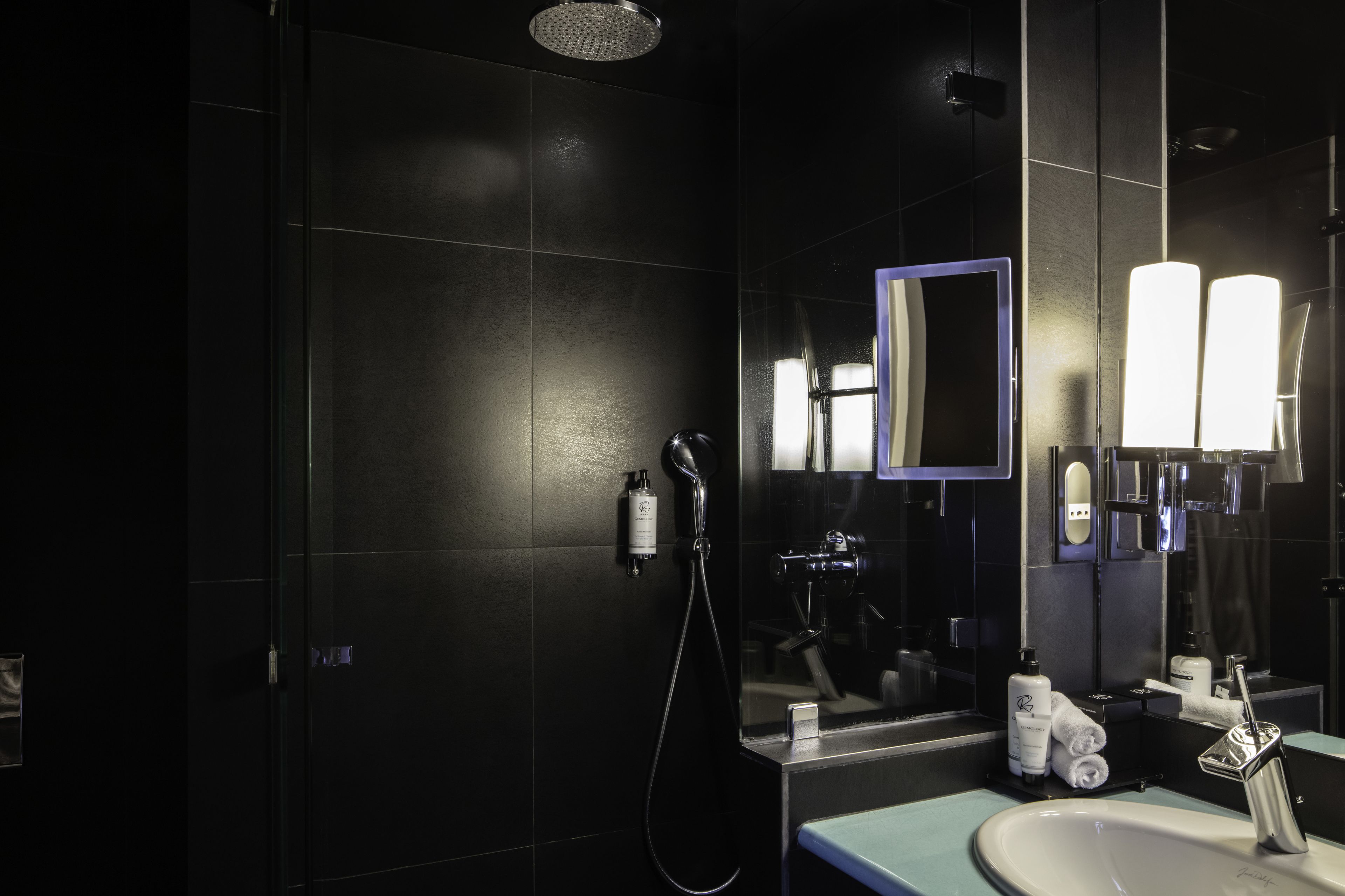 A modern bathroom with a shower, a sink, and a mirror.