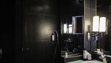 A modern bathroom with a shower, a sink, and a mirror.