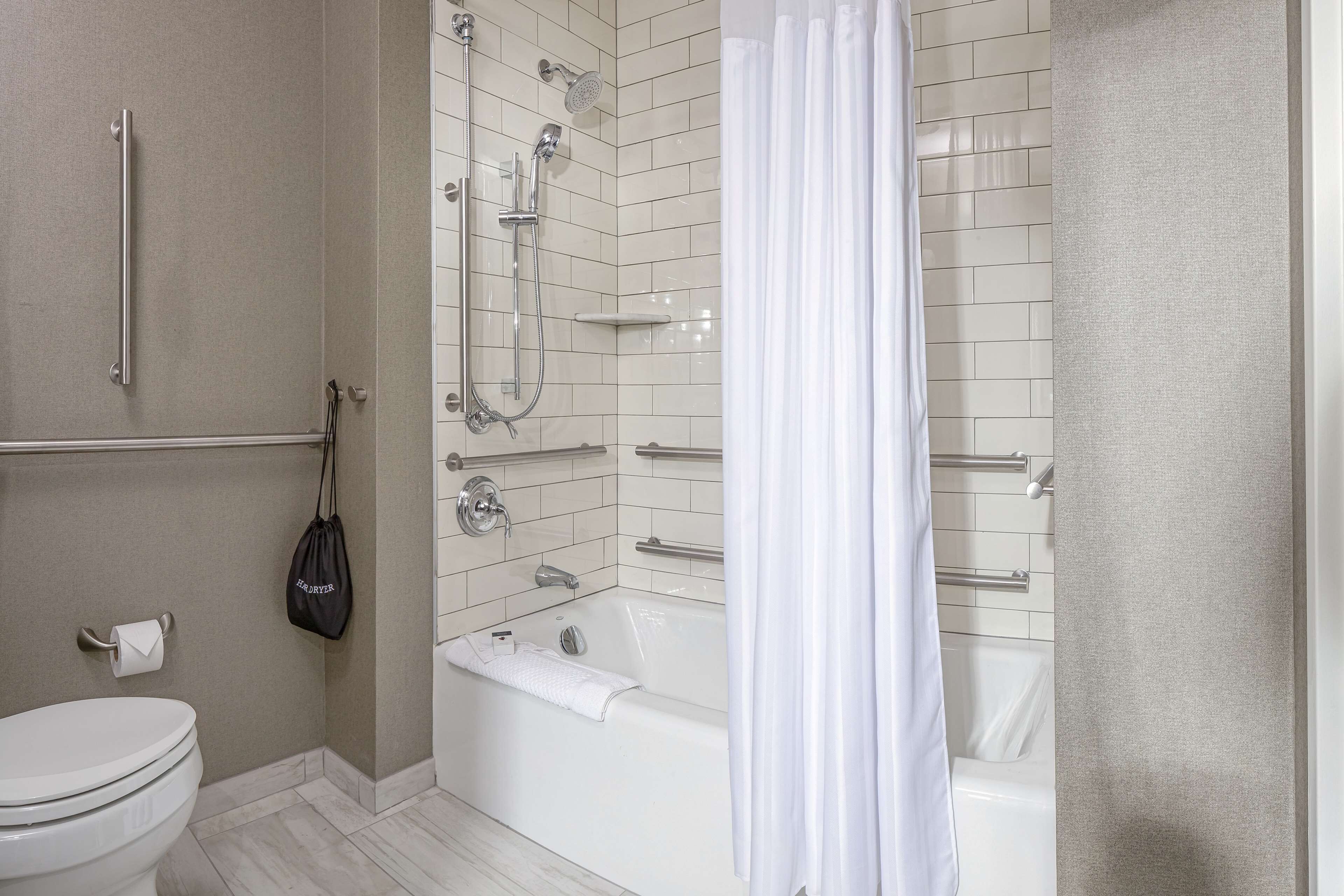 Une salle de bain comprenant des toilettes, une baignoire et un espace douche.