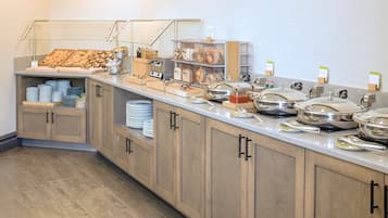 A buffet setup with various food items and serving utensils.