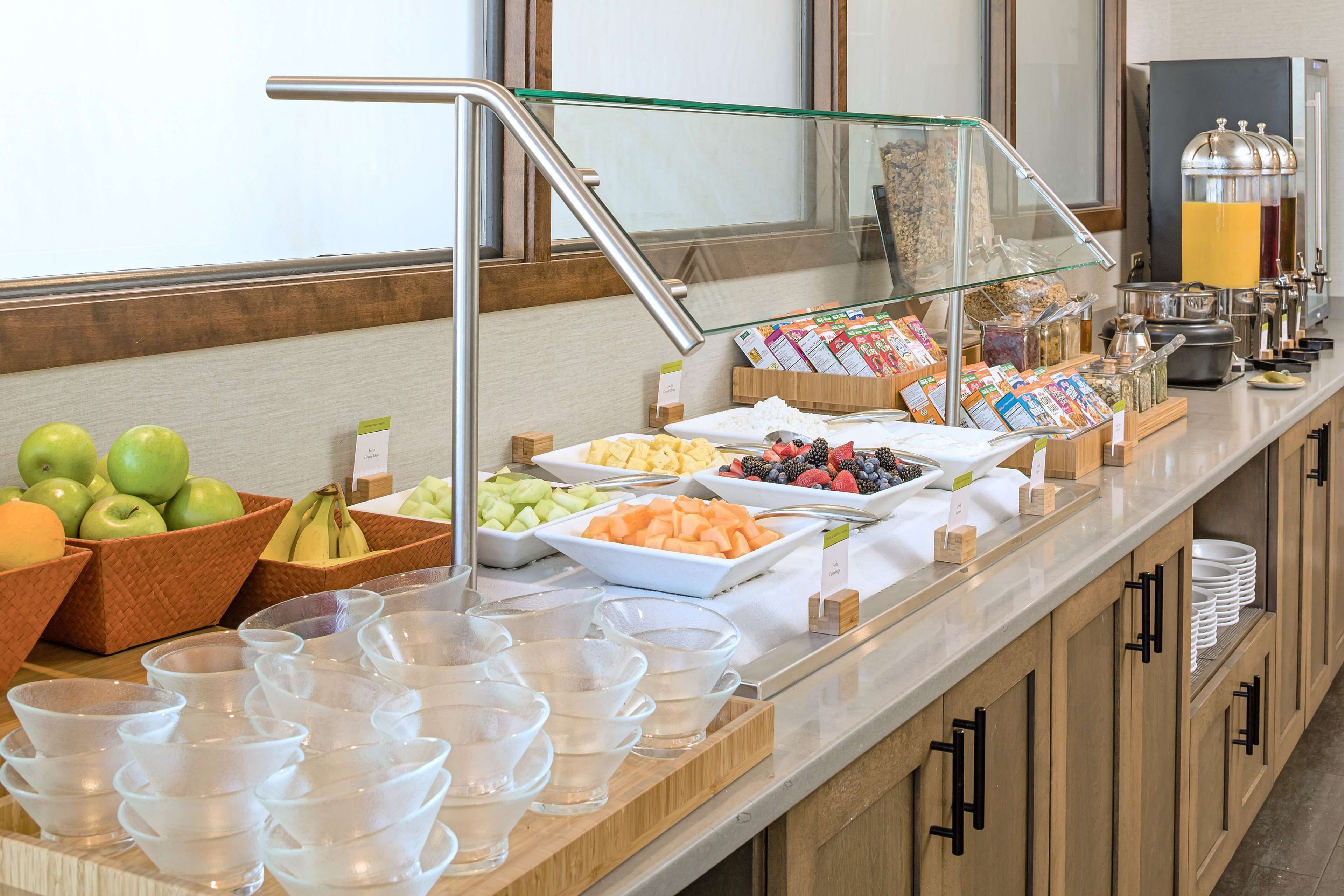 Un bufé con diversas frutas, verduras y bebidas.