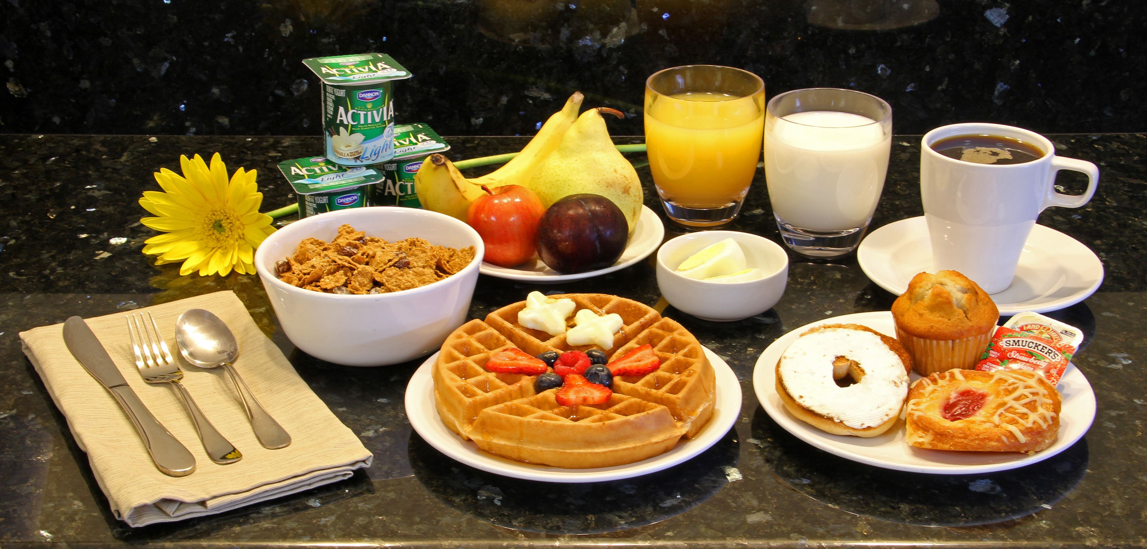 Una escena de desayuno con diferentes alimentos y bebidas sobre una encimera de cocina.