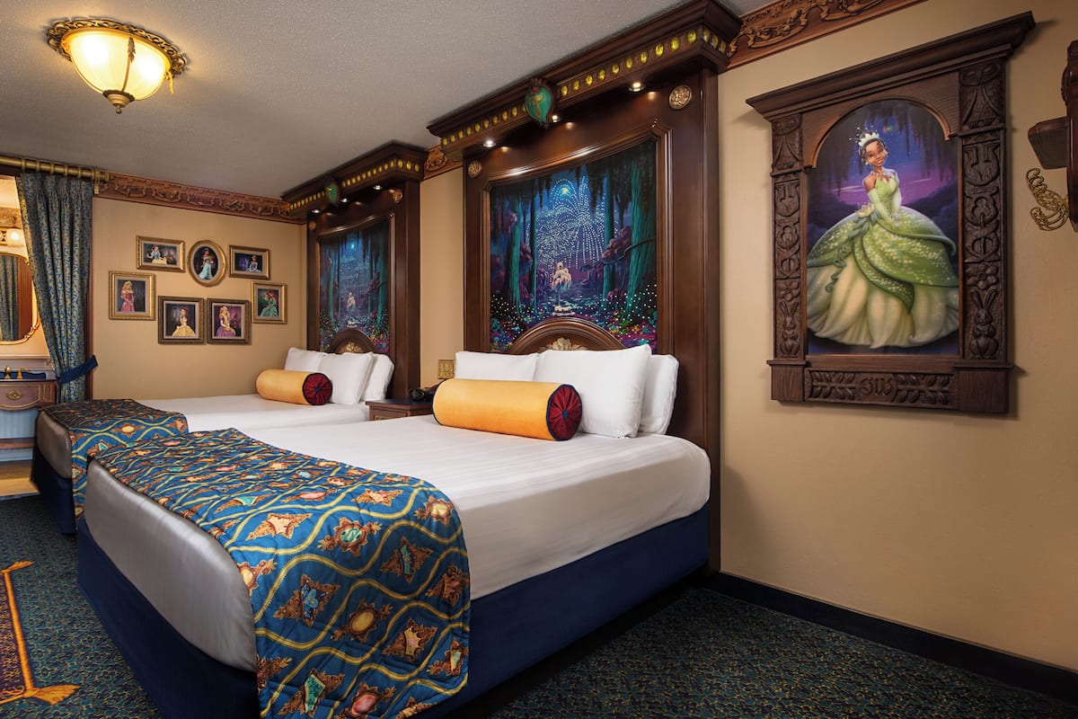 Una habitación de hotel con dos camas, un tocador con espejo y un cuadro grande en la pared.