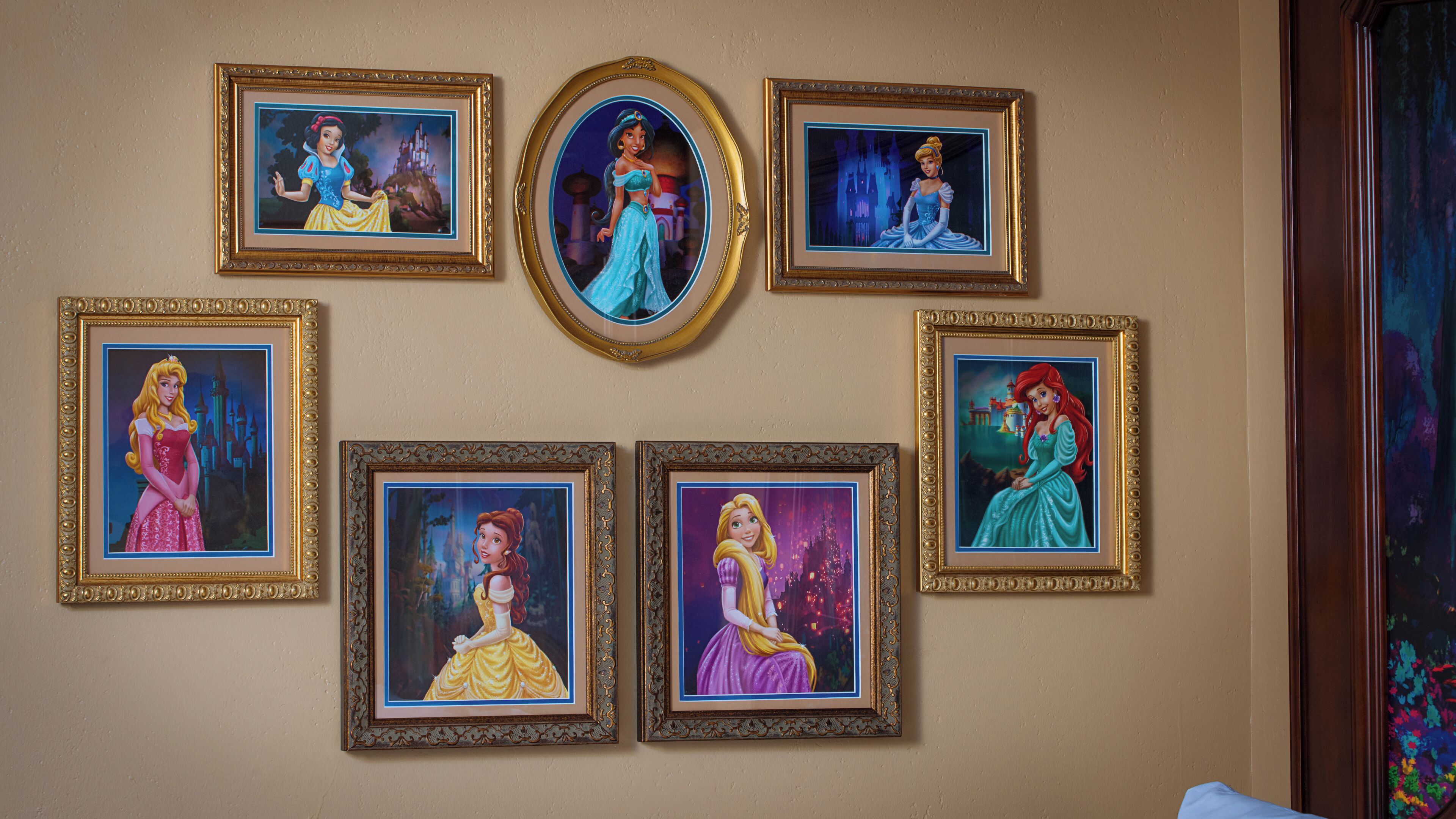 Een muur met ingelijste foto's van geanimeerde prinsessen.