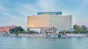 Un hotel moderno con fachada de vidrio, situado frente al mar.