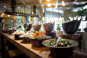 Un buffet proposant divers plats, notamment un plat de légumes verts, un dessert et un plat principal.