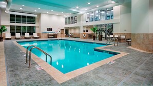 A large indoor swimming pool with clear blue water, surrounded by lounge chairs and a reception area. - DoubleTree by Hilton Hotel Bristol, Connecticut (Bristol)