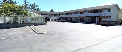 Ein Motel mit Parkplatz, Glasfassade und rotem, weißen Außenbereich.