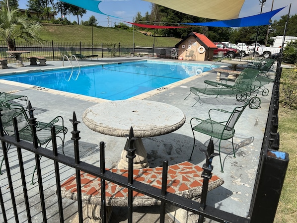A swimming pool with lounge chairs and a small building in the background. - Country Hearth Inn & Suites Cartersville (Cartersville)