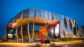A modern building with a unique angular design, large glass windows, and a prominent sculpture in front.