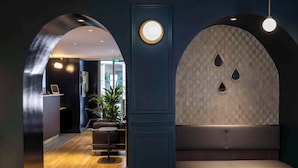 A modern interior with a reception desk, seating area, and a wall with decorative elements.