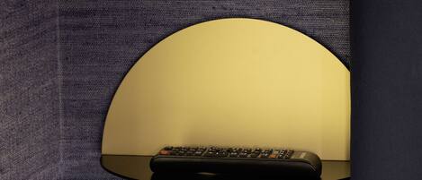 A remote control on a black surface with a circular, illuminated background.