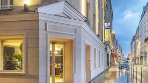A hotel with a classic facade, large windows, and a sign indicating it is a Best Western hotel.