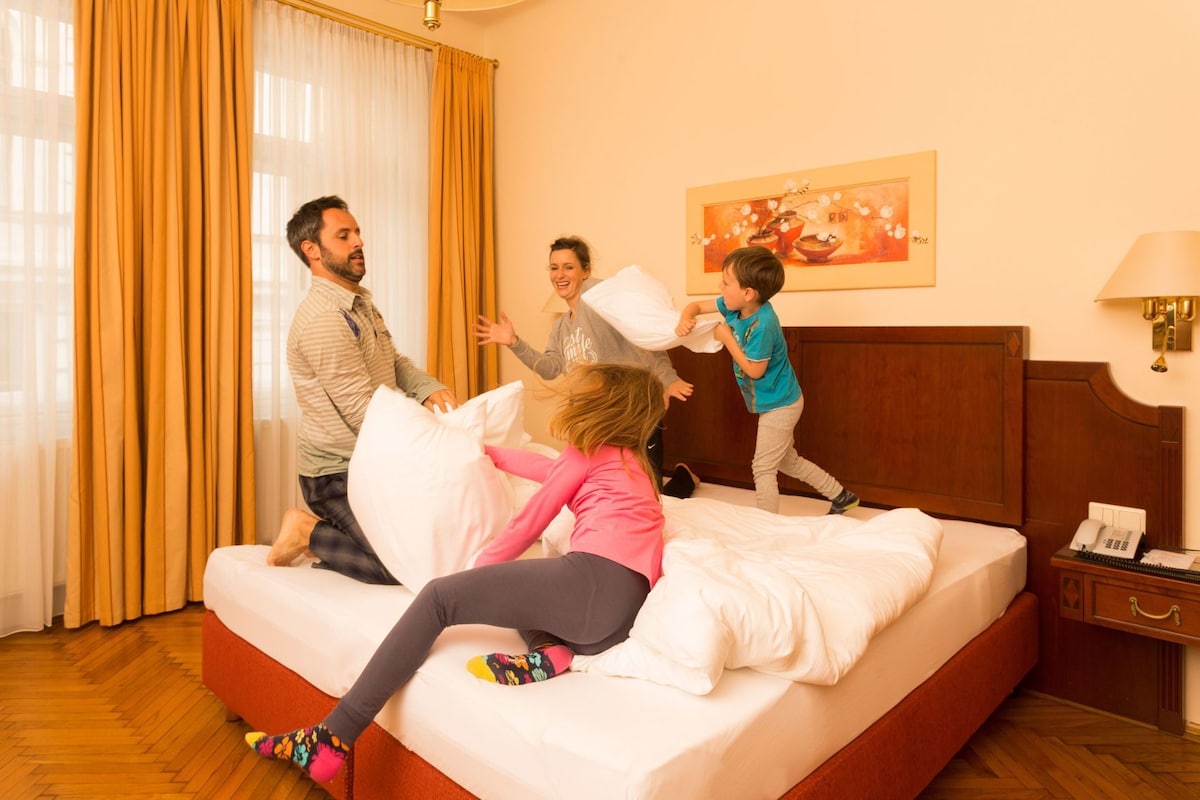 A hotel room with a bed, a nightstand, a lamp, and a painting on the wall.