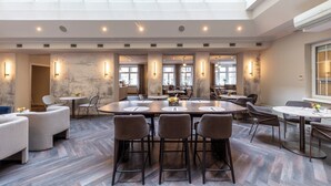 A spacious dining area with high ceilings, large windows, and modern furnishings. - Hotel City Central (Vienna)