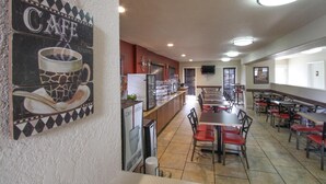 A cafe with a counter, seating area, and a wall with a cafe sign. - GreenTree Inn Flagstaff (Flagstaff)