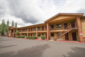 A motel with a central corridor, individual rooms on either side, and a parking lot in front.