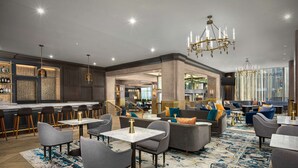 Een moderne lounge met een bar, banken en een kamerbreed tapijt met patroon.