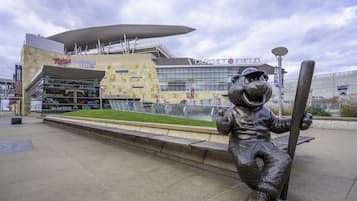 A stadium with a large mascot statue holding a bat, a Target store, and a Twins Clubhouse Store.