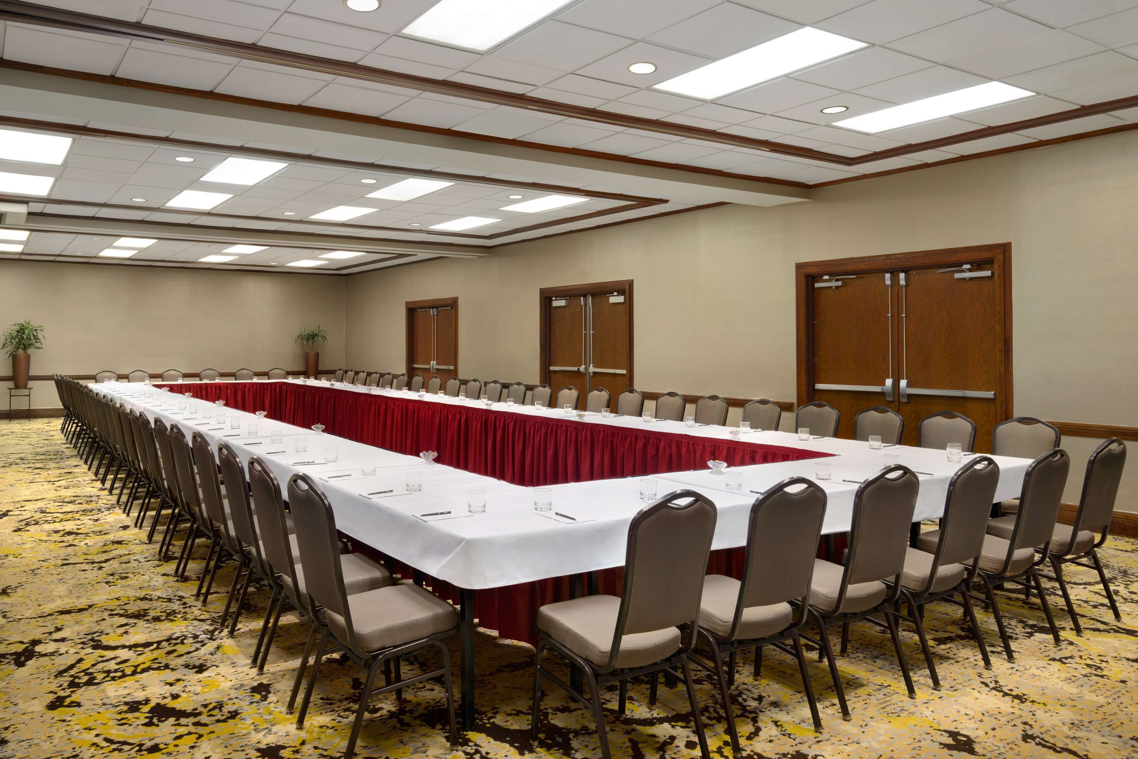 Une salle de conférence avec une longue table, des chaises et un sol recouvert de moquette.