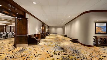 Un vestíbulo de hotel con alfombra estampada, zonas de estar y un letrero que dice 'Grove I'.
