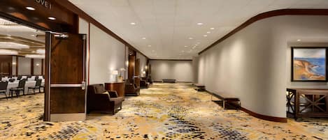 A hotel lobby with a patterned carpet, seating areas, and a 'Grove I' sign.