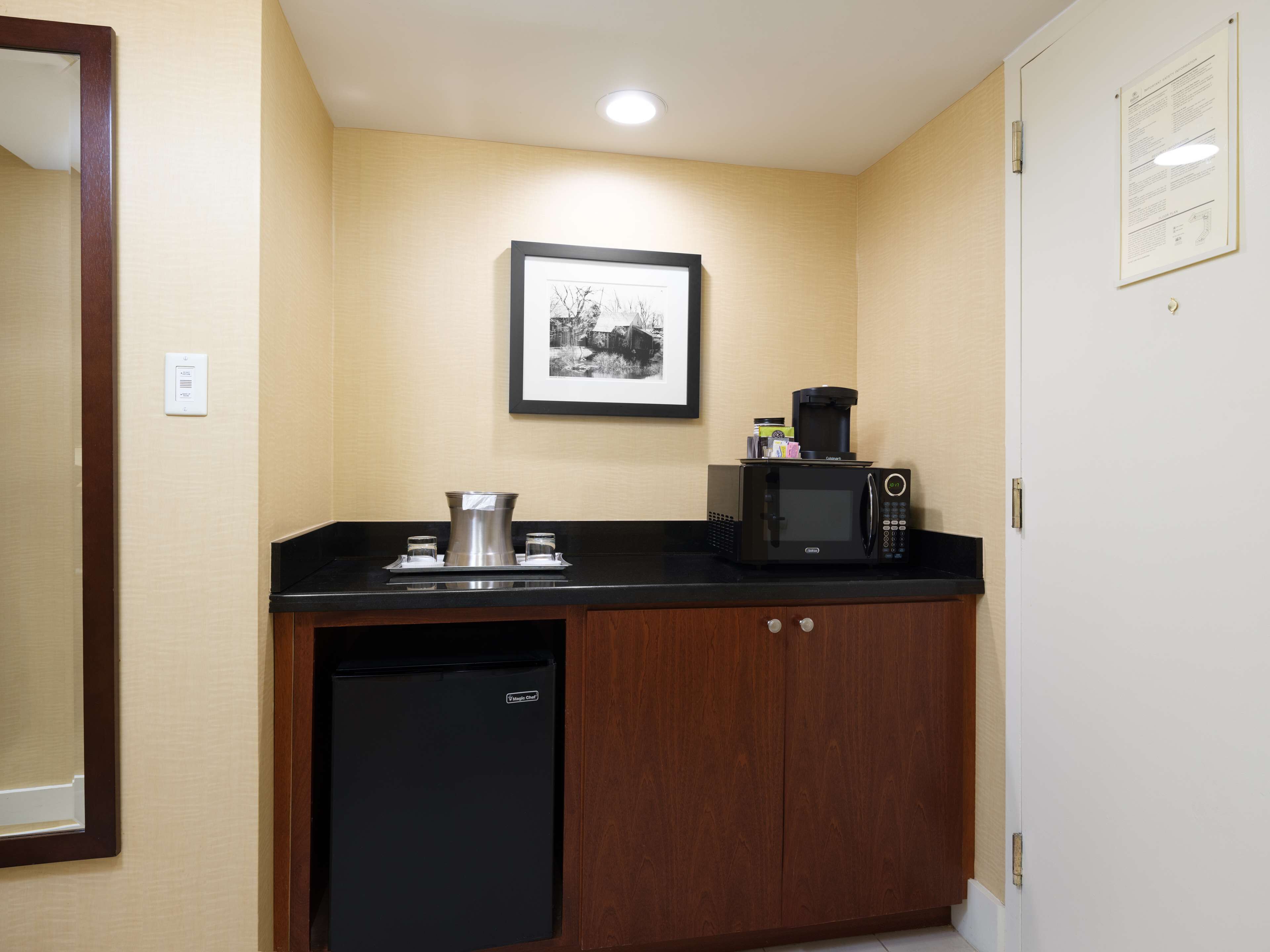 A compact kitchenette with a microwave, coffee maker, and a small refrigerator.