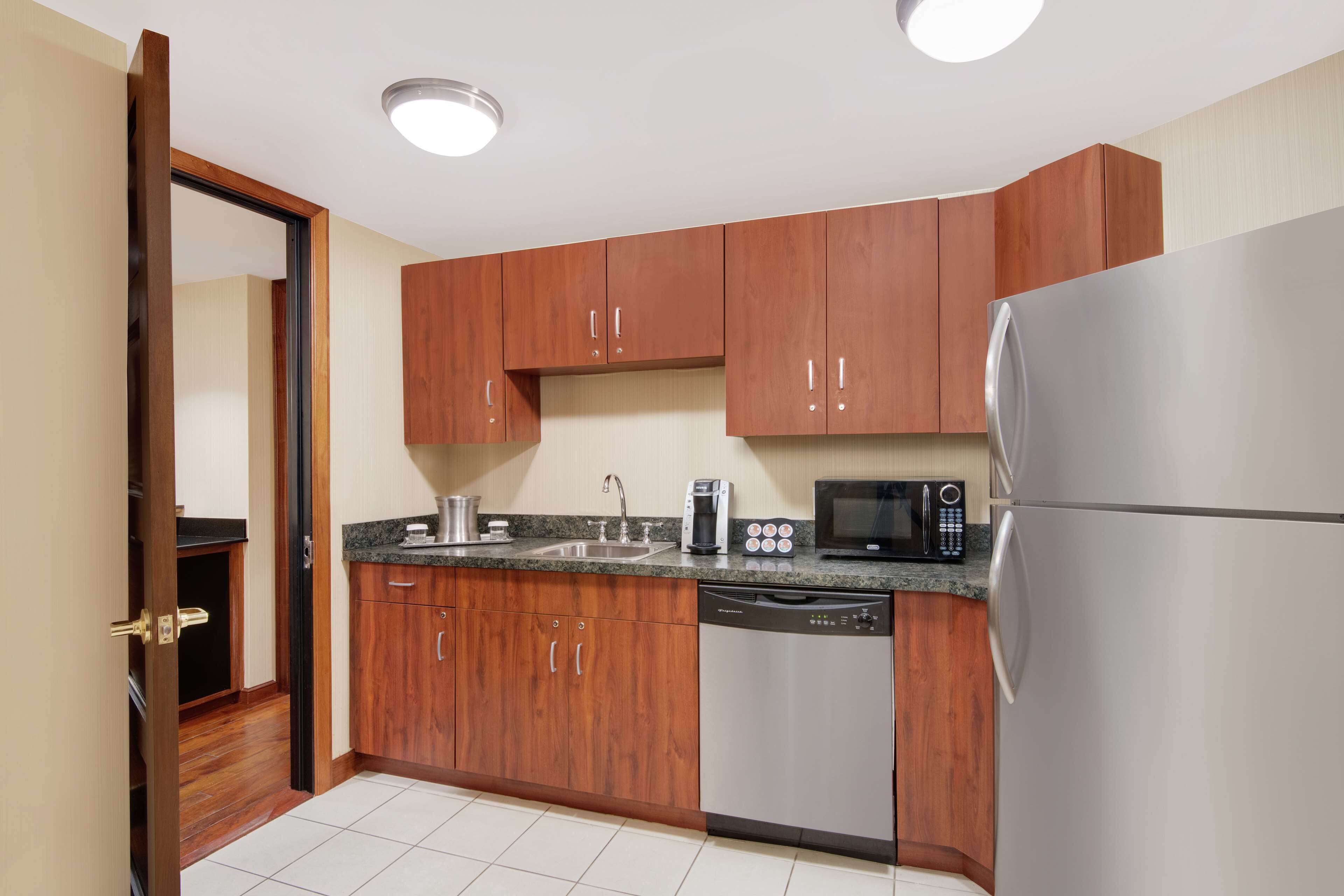 A kitchen with wooden cabinets, stainless steel appliances, a dishwasher, and a microwave.