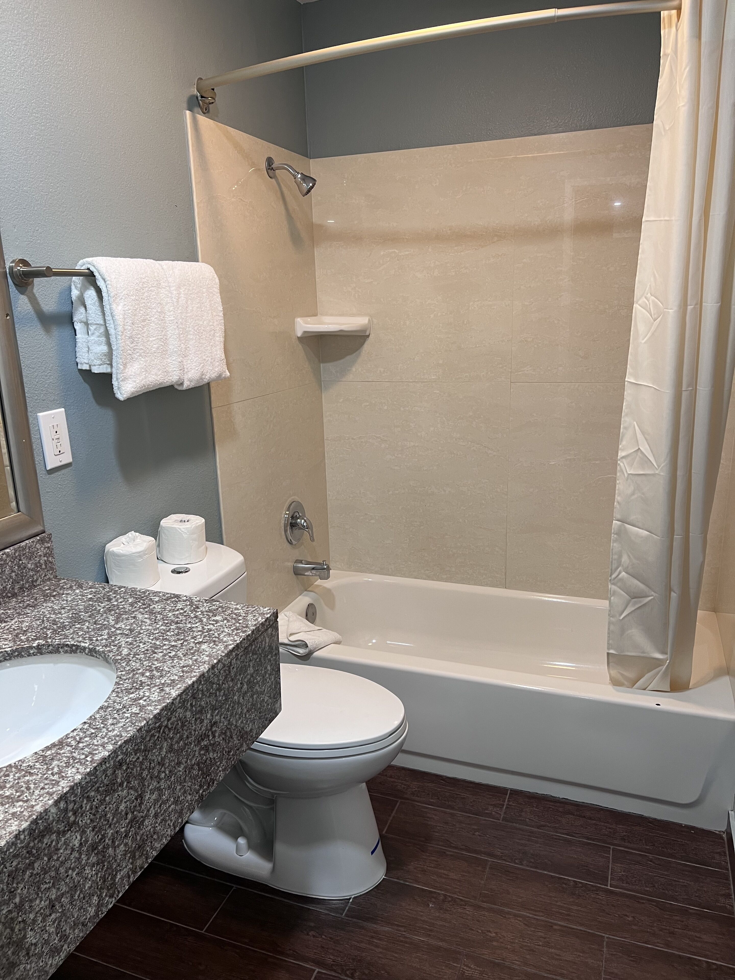 A bathroom with a shower, toilet, and sink.