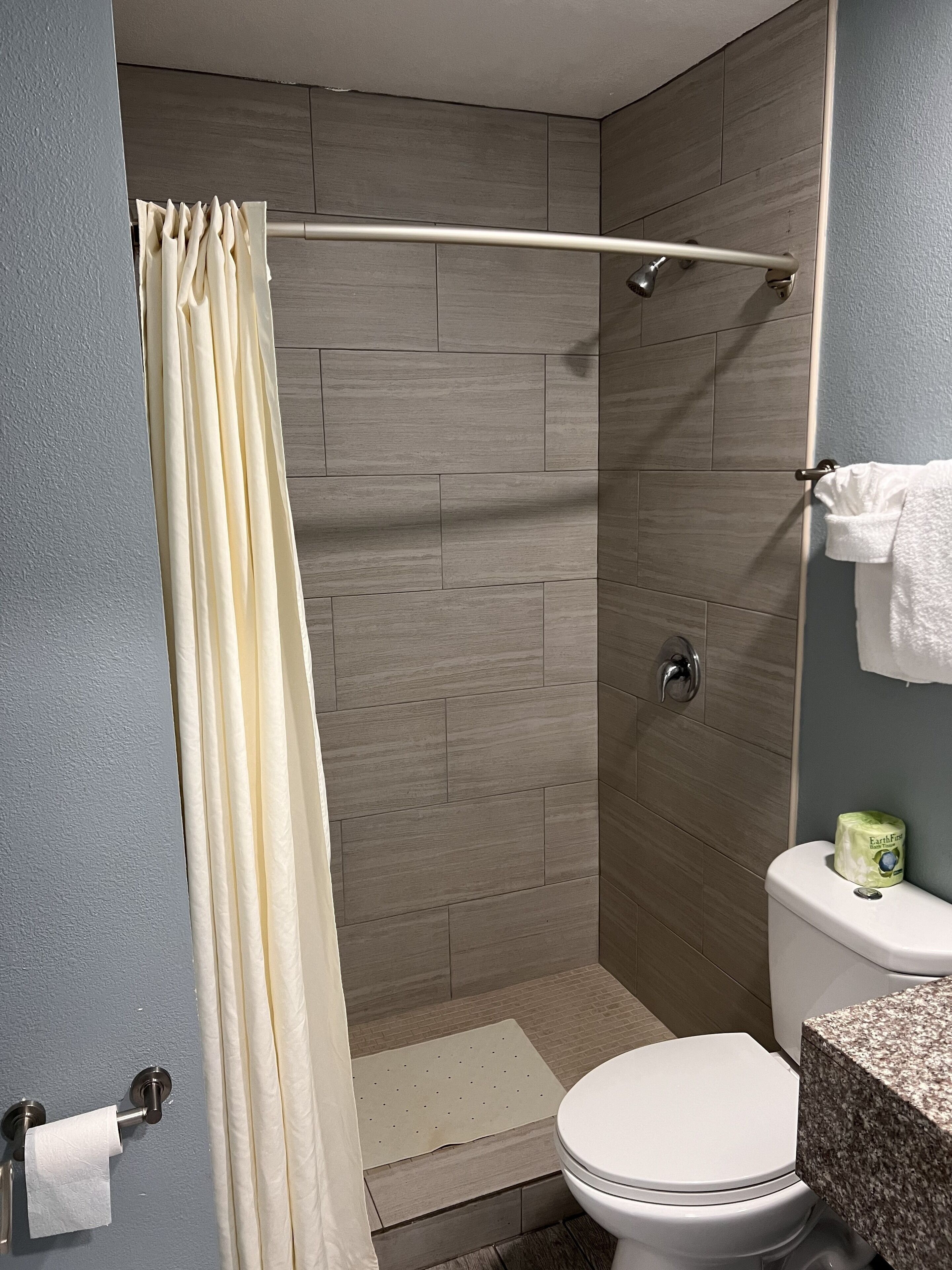 A bathroom with a shower, toilet, and sink.