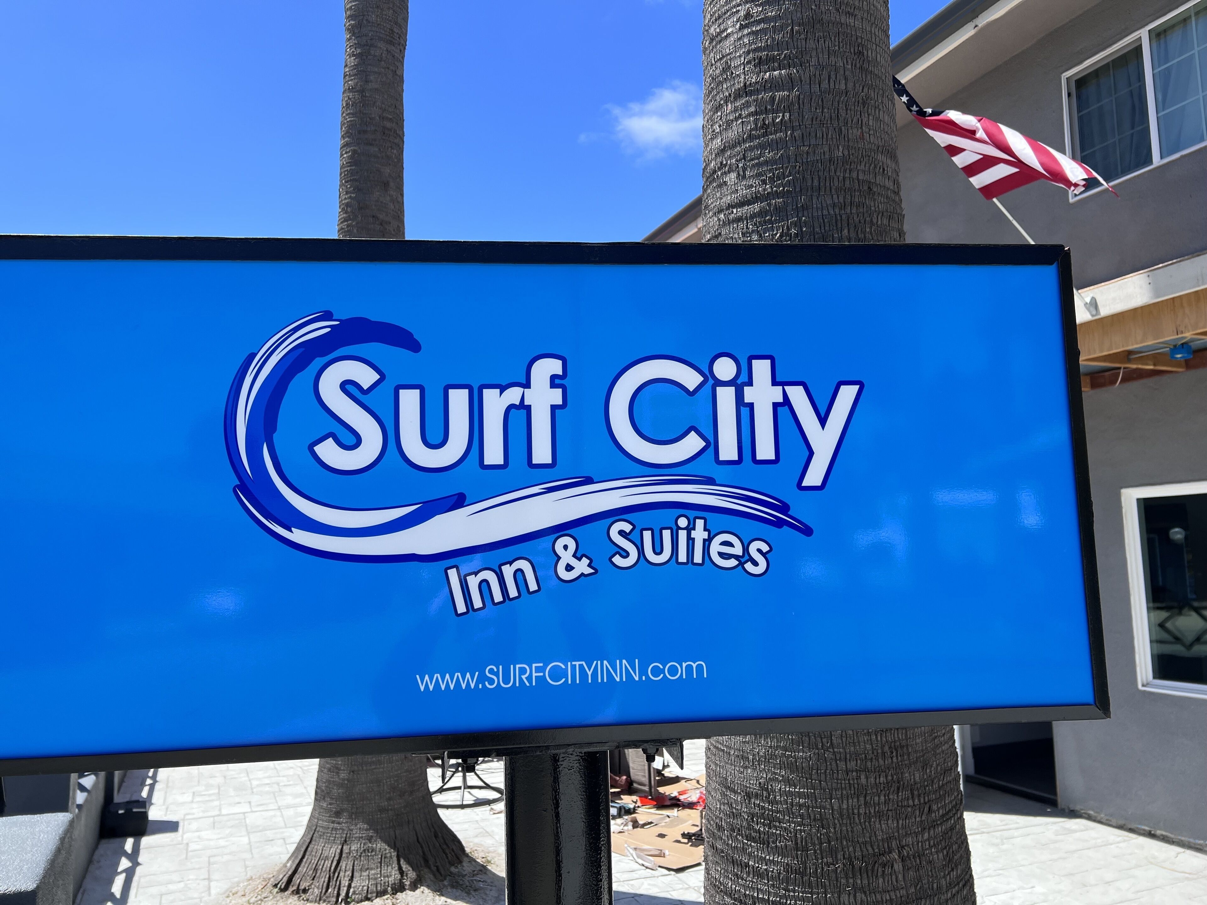 Een bord van Surf City Inn & Suites met een websiteadres.