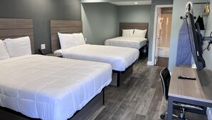 A hotel room with three beds, a desk, and a chair. - Surf City Inn and Suites (Santa Cruz)