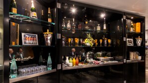 A bar area with shelves of bottles, glasses, and a buffet setup. - Hôtel Sezz Paris (Paris)