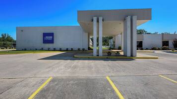 Stylish building with a flat roof and large overhang supported by two columns.