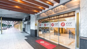 A hotel entrance with a modern design, featuring a marble floor and a red doormat. - Exe Hotel Colón (Buenos Aires)