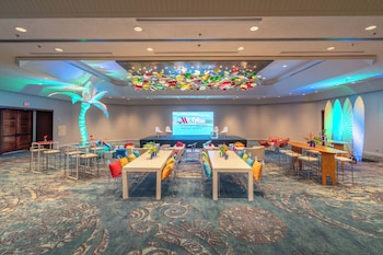 A spacious gym with various exercise equipment, large windows, and a modern ceiling design. at Waikiki Beach Marriott Resort & Spa