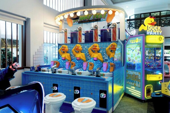 A brightly lit indoor space with a central counter featuring a duck-themed design, including a 'Duck Party' sign and a water play area with duck-shaped toys. - Waikiki Beach Marriott Resort & Spa (Honolulu)