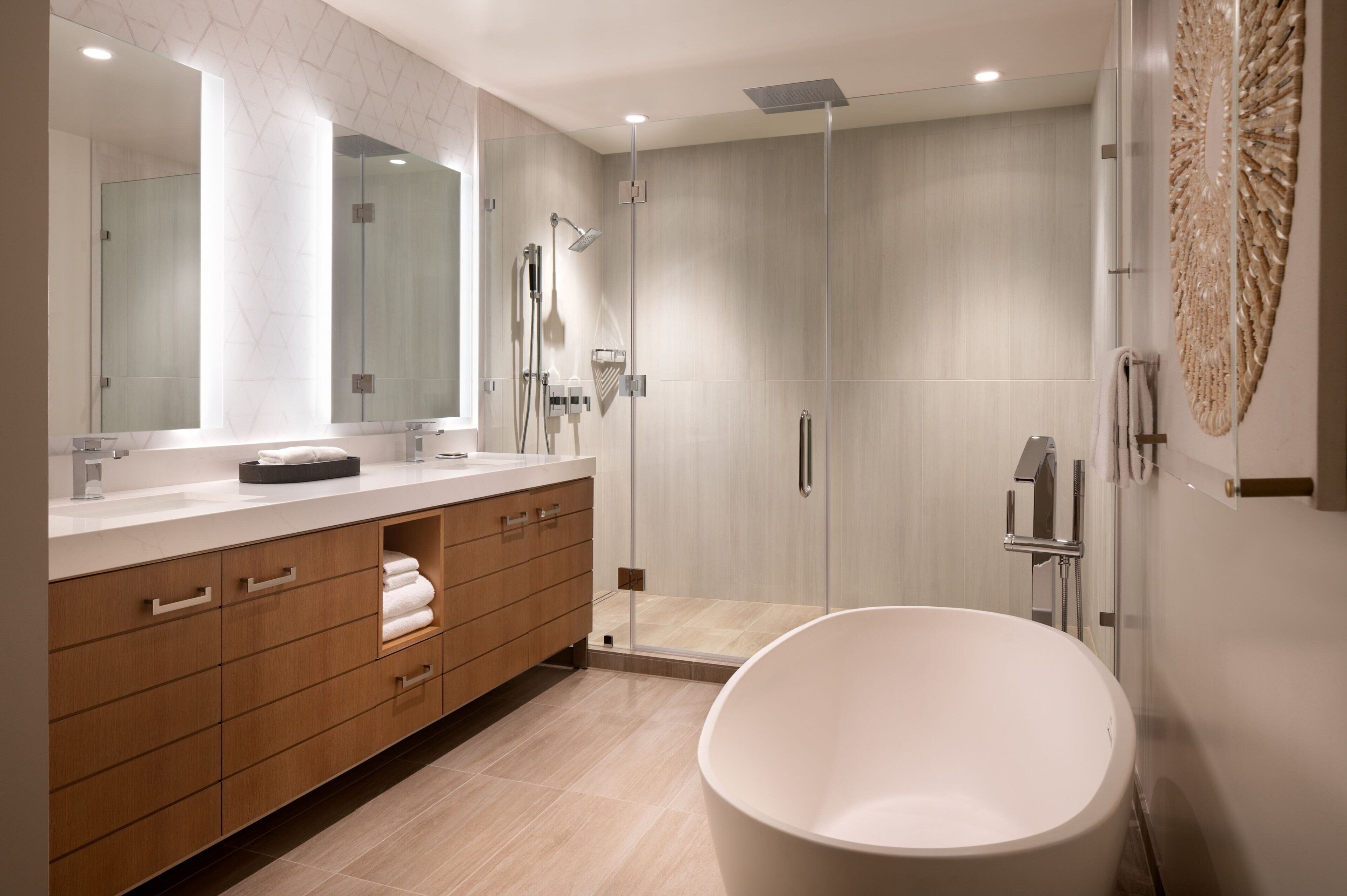 A modern bathroom with a large bathtub, a walk-in shower, and a vanity with a mirror.