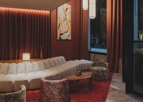 A modern living room with a sectional sofa, a coffee table, and two ottomans.