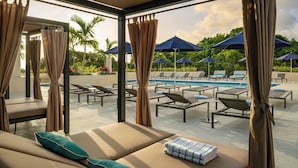 A poolside lounge area with sun loungers, a pool, and umbrellas. - Fort Lauderdale Marriott North (Fort Lauderdale)