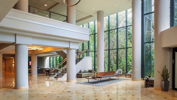 A spacious lobby with a high ceiling, large windows, and a central seating area. - Fort Lauderdale Marriott North (Fort Lauderdale)