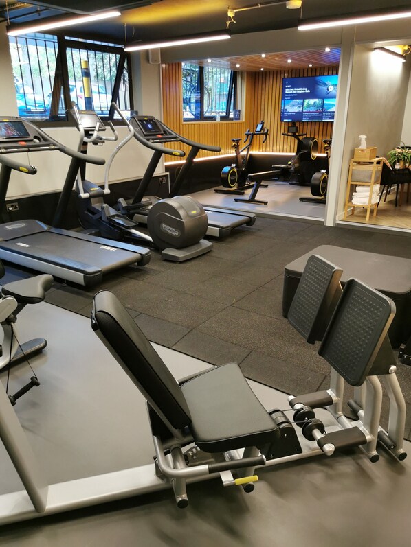 A gym with treadmills, elliptical machines, and weight benches. - Richmond Hill Hotel (Richmond)