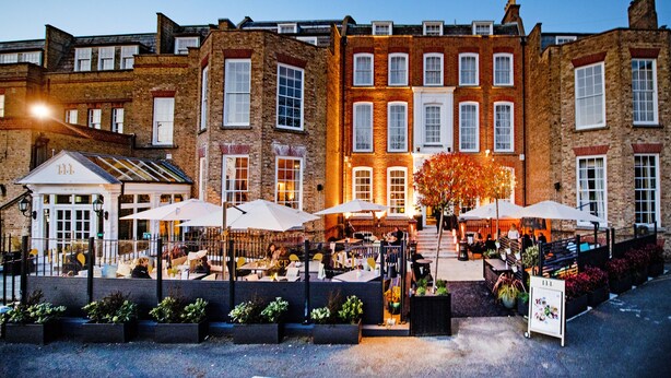 A historic building with a courtyard, outdoor seating, and a signboard. - Richmond Hill Hotel (Richmond)
