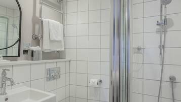 Une salle de bain moderne avec une douche à parois de verre, un lavabo blanc et un miroir.
