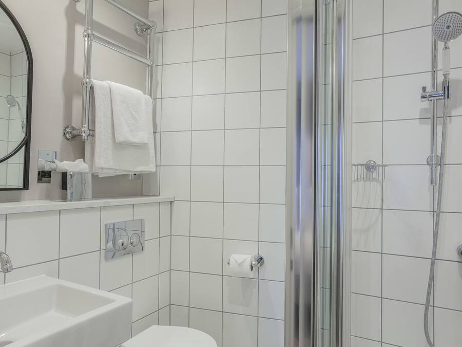 Une salle de bain moderne avec une douche à parois de verre, un lavabo blanc et un miroir.