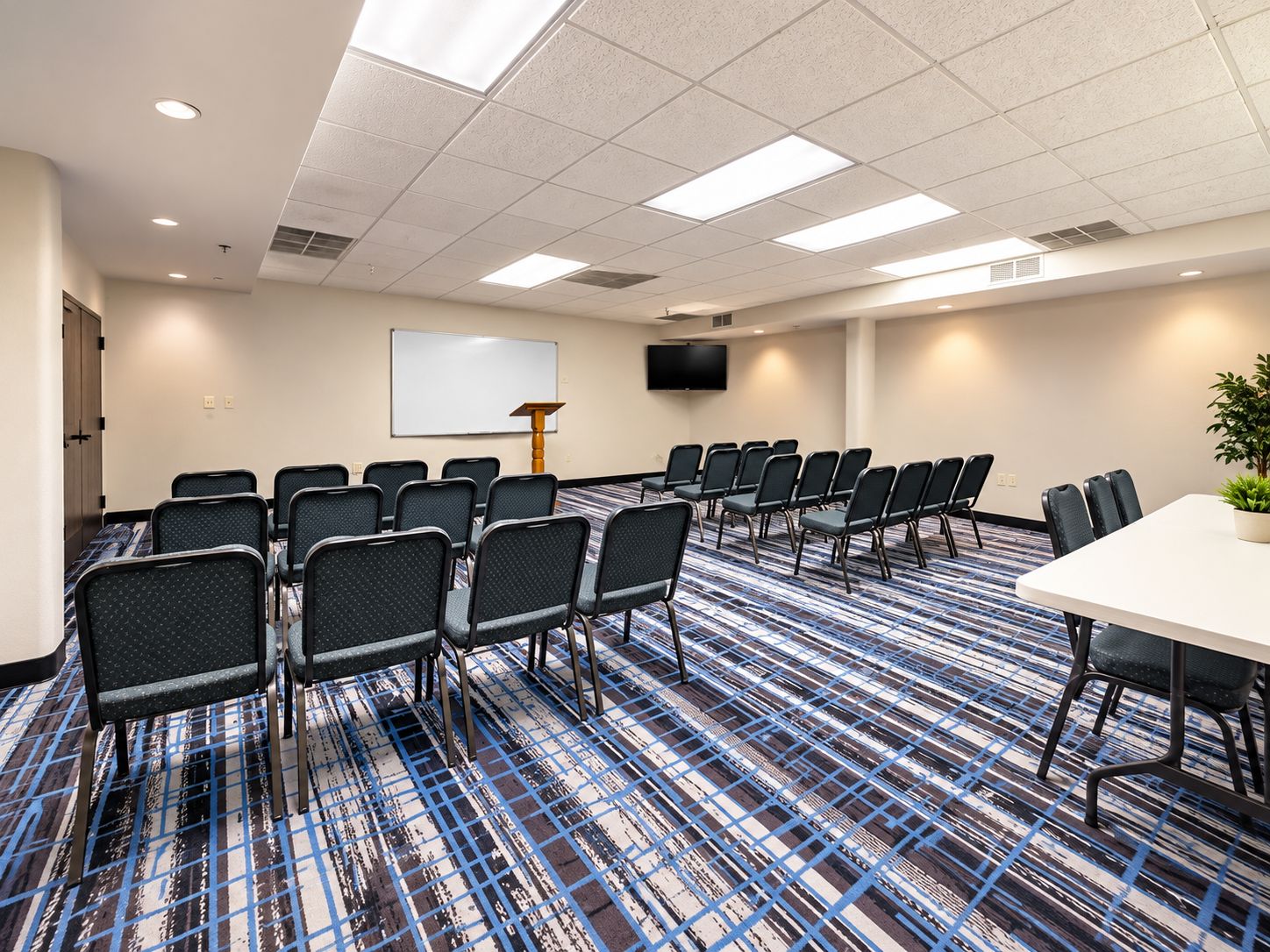 A conference room with a whiteboard, a TV, and a large table.
