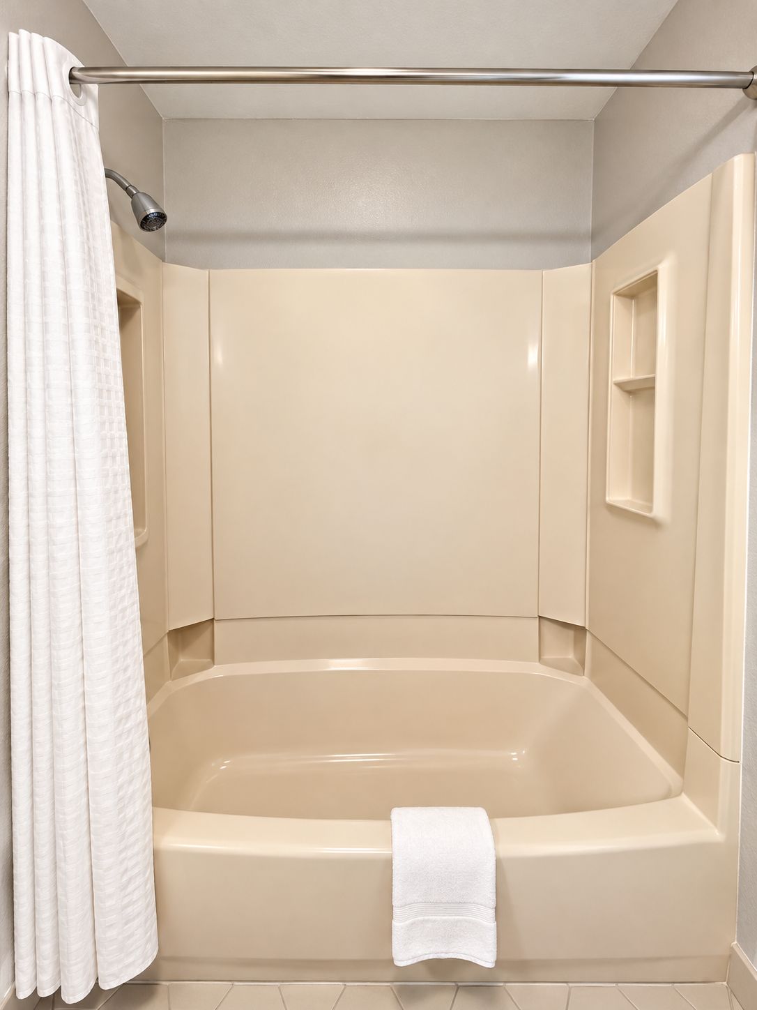 A bathroom with a bathtub, a shower curtain, and a towel.