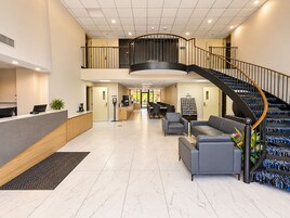 Un hall espacioso con recepción, zona de estar y una escalera.
