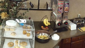 A buffet setup with various food items and utensils. - Gold Vault Inn (Radcliff)